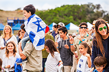 scout carries boy wrapped in Israeli flag